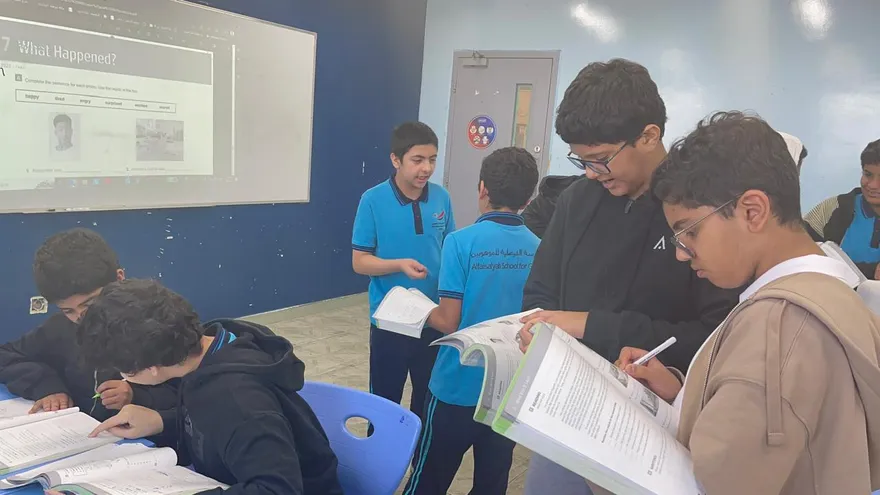 Students discussing over books in an active English lesson