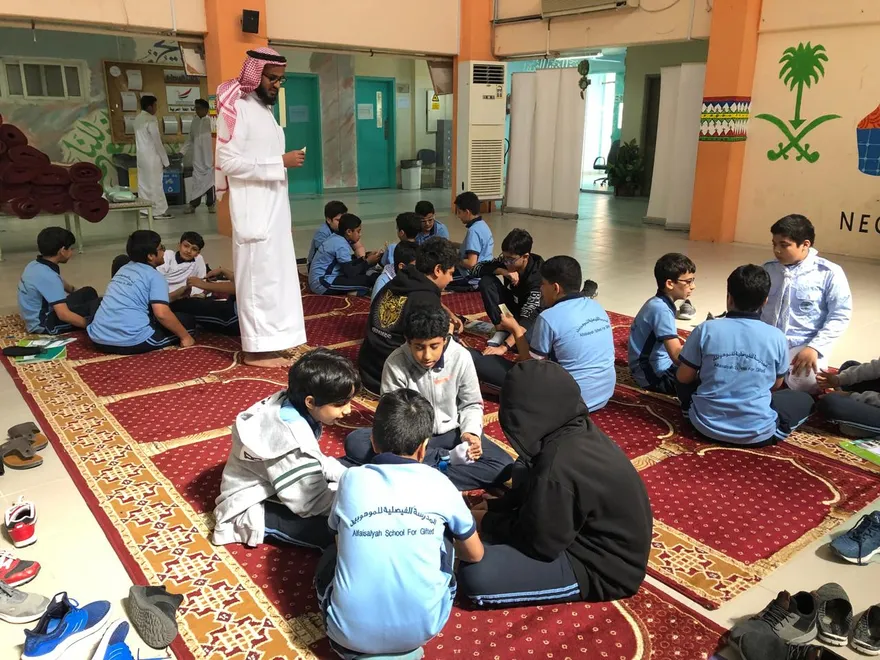 معلم يتابع مجموعات الطلاب في حلقات تعلم داخل مدرسة الفيصلية