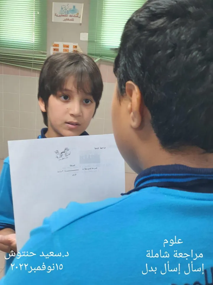 طالب يعرض ورقة مراجعة على زميله في نشاط تقييم بين الأقران