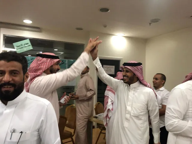 معلمان يتبادلان التحية بحماس في ورشة تدريبية