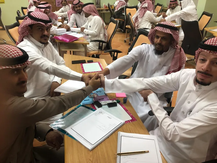 معلمون يتشابكون بالأيدي في ورشة تدريبية تعاونية